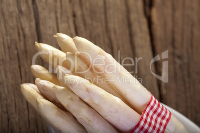 Spargelspitzen vor Holzwand