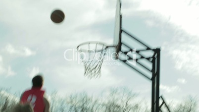 Men playing basketball in a city park. Sequence