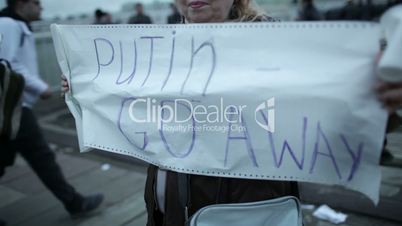 Woman holds a placard Putin Go Away.