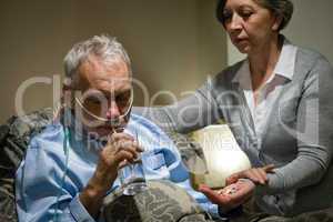Senior man taking medication with water