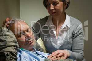 Caring nurse with sleeping senior male patient