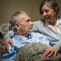 Ill old man lying bed with wife