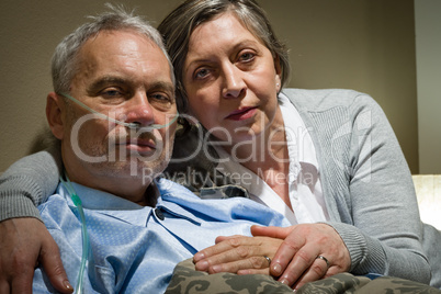 Anxious senior wife holding her sick husband