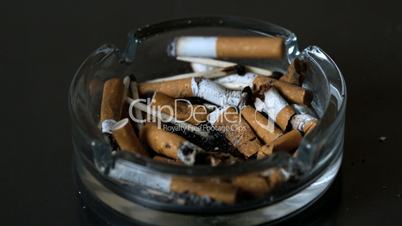 Cigarette falling into ashtray