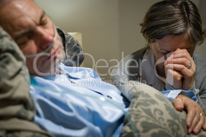 Old wife praying for terminally ill husband