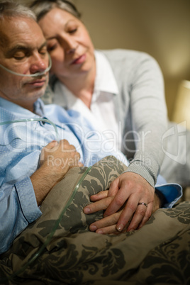 Loving elderly couple sleeping in bed