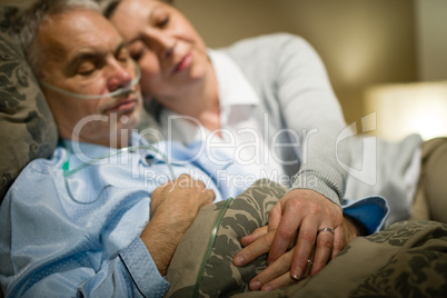 Retired ill man and caring wife sleeping