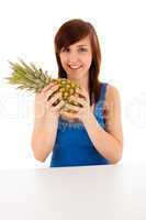 Die junge Frau mit einer großen Ananas
