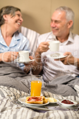 Mature couple enjoying breakfast at hotel room