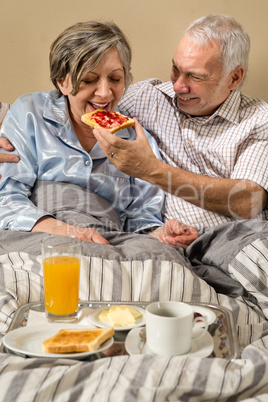 Senior man feeding breakfast to woman