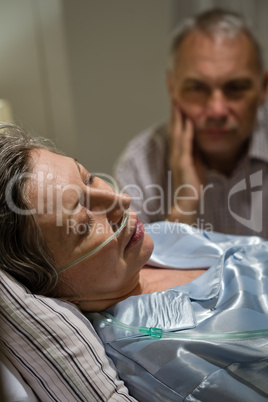 Dying woman in bed with caring man