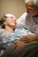 Elderly couple holding hands at clinic ward