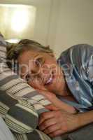 Retired smiling woman lying in bed