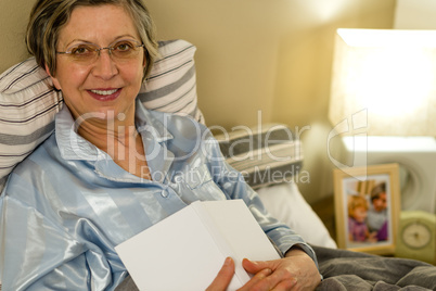 Old woman in pajamas lying in bed