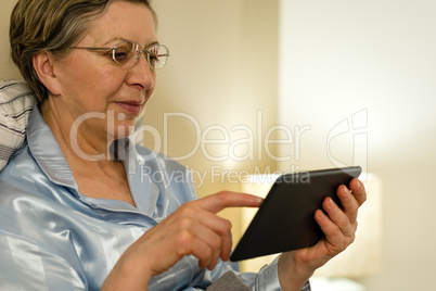 Senior woman using digital tablet in bed