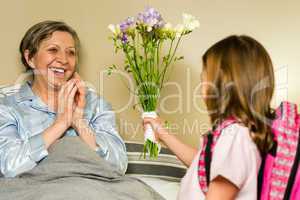 Girl giving bouquet of flowers to grandmother