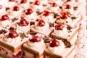 Cream filled cakes with cherry decoration