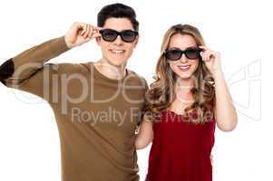 Young couple posing to camera with shades on