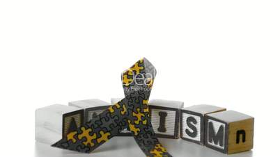 Awareness ribbon falling onto blocks spelling autism