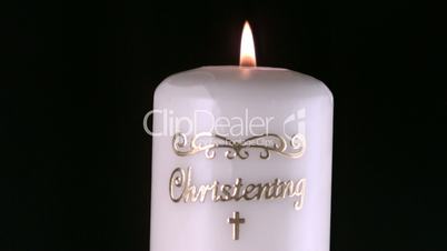 Lit christening candle flickering and going out
