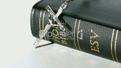 Rosary beads falling onto bible