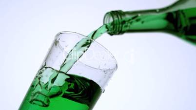 Green liquid pouring into glass