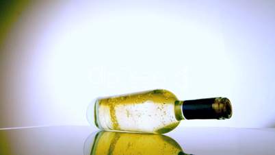 White wine bottle spinning around on white surface