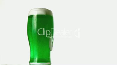 Pint of green beer overflowing