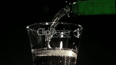Bottle pouring fizzy water into glass