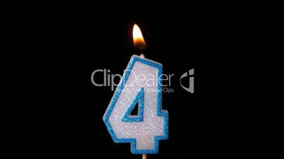 Four birthday candle flickering and extinguishing on black background