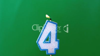 Four birthday candle flickering and extinguishing on green background