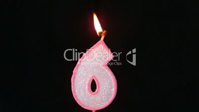 Six birthday candle flickering and extinguishing on black background