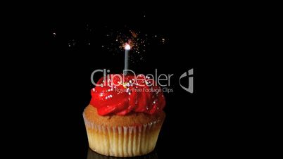 Sparkler burning on red birthday cupcake