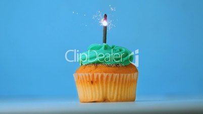 Sparkler burning on blue birthday cupcake