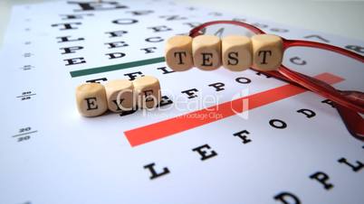 Eye test dice falling onto eye test with reading glasses
