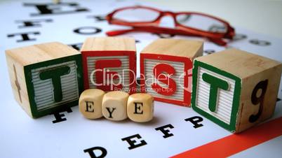 Message for eye test spelled out in dice and blocks on an eye test