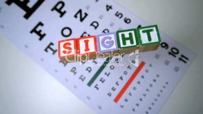 Blocks spelling out sight falling onto eye test