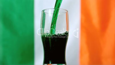 Green beer pouring into pint glass