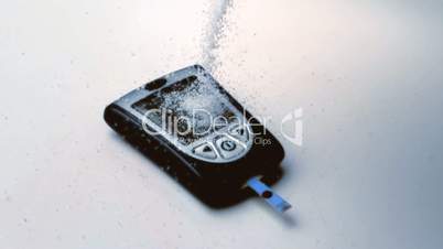 Sugar pouring onto blood glucose monitor