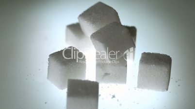 Sugar cube falling onto pile of cubes