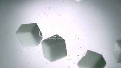 Sugar cubes falling onto white surface