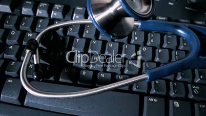 Stethoscope falling onto computer keyboard