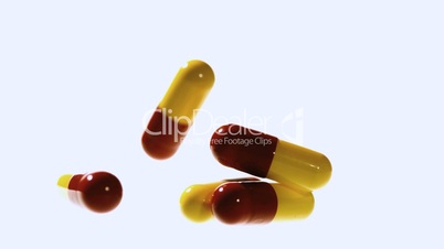Red and yellow capsule tablet falling and bouncing on others close up
