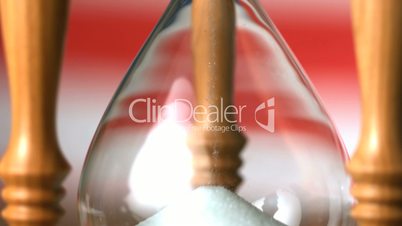 Sand flowing through hourglass with american flag background close up