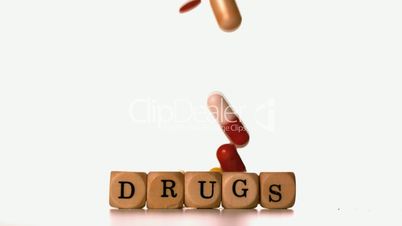 Different tablets falling on dice spelling drugs