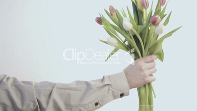 Man placing bunch of tulips in vase