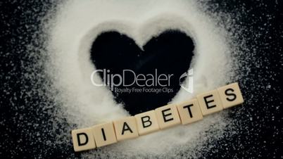 Focus on heart shaped out of sugar with diabetes message and syringe falling