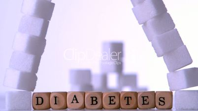 Wall of sugar cubes falling over dice spelling out diabetes