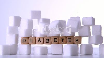 Sugar cubes falling in front of dice spelling out diabetes
