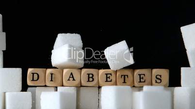 Sugar cubes and dice spelling diabetes falling down in black background